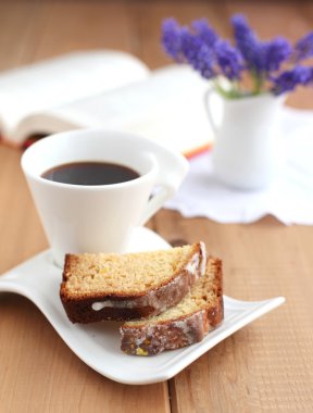 Sliced orange cake with cup of coffee clipart