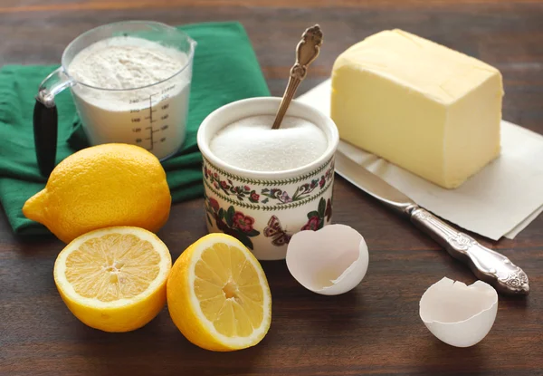 Ingrediënten voor cake - meel, suiker, eieren, boter en citroenen — Stockfoto