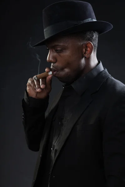 Schwarzer Mann mit Hut und rauchender Zigarre — Stockfoto