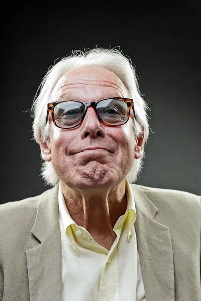 Uomo anziano che indossa tuta leggera e occhiali da sole vintage isolati su sfondo scuro . — Foto Stock