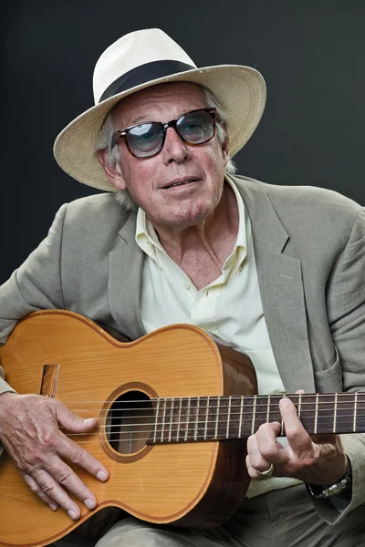 Senior jazz musician with accoustic guitar wearing suit hat and vintage sunglasses. — Stock Photo, Image