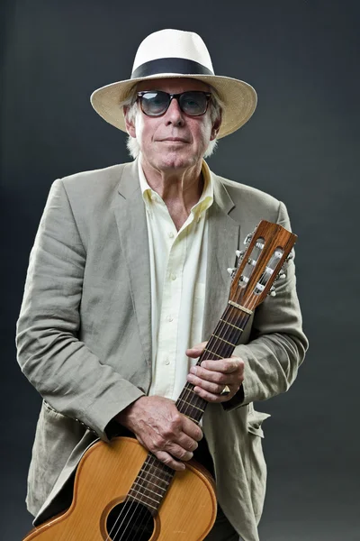 Senior jazz musician with accoustic guitar wearing suit hat and vintage sunglasses. — Stock Photo, Image