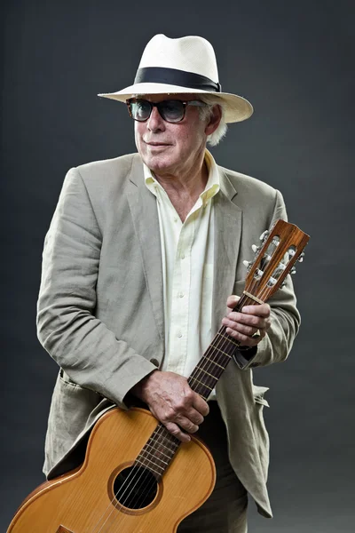 Старший джазовый музыкант с акустической гитарой в шляпе в костюме и старинных солнцезащитных очках . — стоковое фото