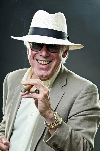 stock image Senior gangster man smoking cigar wearing light suit and hat with vintage sunglasses.