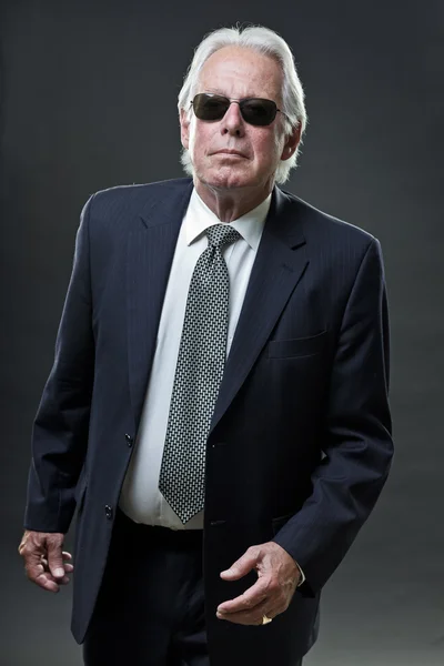 Senior business man klädd i mörk blå kostym och svarta solglasögon. — Stockfoto