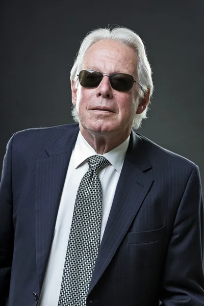 Senior business man wearing dark blue suit and black sunglasses. — Zdjęcie stockowe
