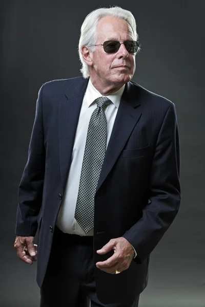 Senior business man klädd i mörk blå kostym och svarta solglasögon. — Stockfoto