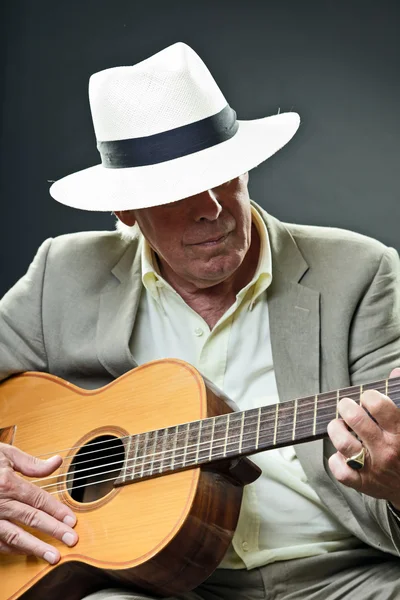 Ανώτερος μουσικός τζαζ με ακουστική κιθάρα φορώντας καπέλο και γυαλιά ηλίου. — Φωτογραφία Αρχείου