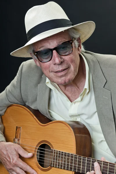Старший джазовый музыкант с акустической гитарой в шляпе и солнечных очках . — стоковое фото