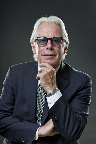 Homem de negócios sênior vestindo terno azul escuro e óculos de sol retro . — Fotografia de Stock