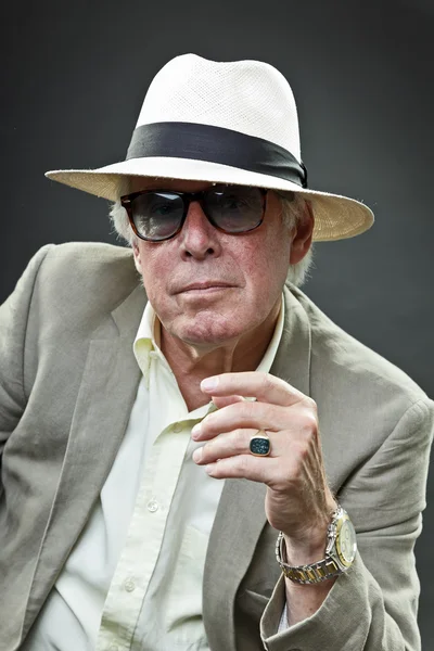 Senior man in pak dragen van een hoed en vintage zonnebril. — Stockfoto
