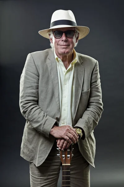 Senior man met akoestische gitaar pak hoed en zonnebril dragen. — Stockfoto