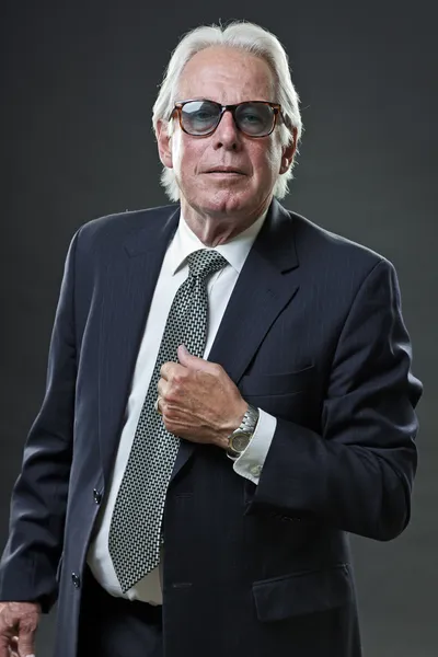 Hombre de negocios senior con traje azul oscuro corbata y gafas de sol . —  Fotos de Stock