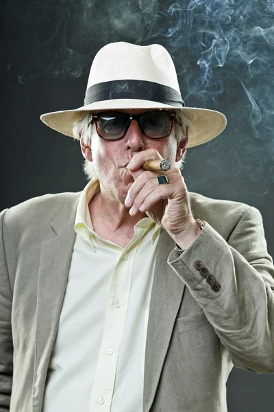 Senior man met hoed en zonnebril sigaar roken. — Stockfoto