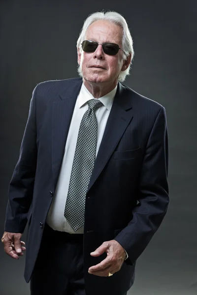 Hombre de negocios senior con gafas de sol aisladas sobre fondo gris . —  Fotos de Stock