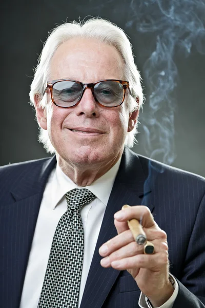 Senior mannen i kostym röka cigarr. — Stockfoto