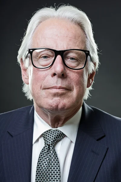 Vezető üzleti férfi vintage szemüveget visel, sötét kék öltöny és a nyakkendő — Stock Fotó