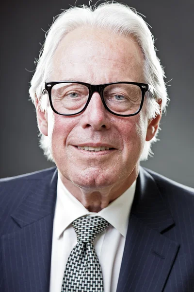 Homem de negócios sênior com óculos vintage vestindo terno azul escuro e gravata — Fotografia de Stock