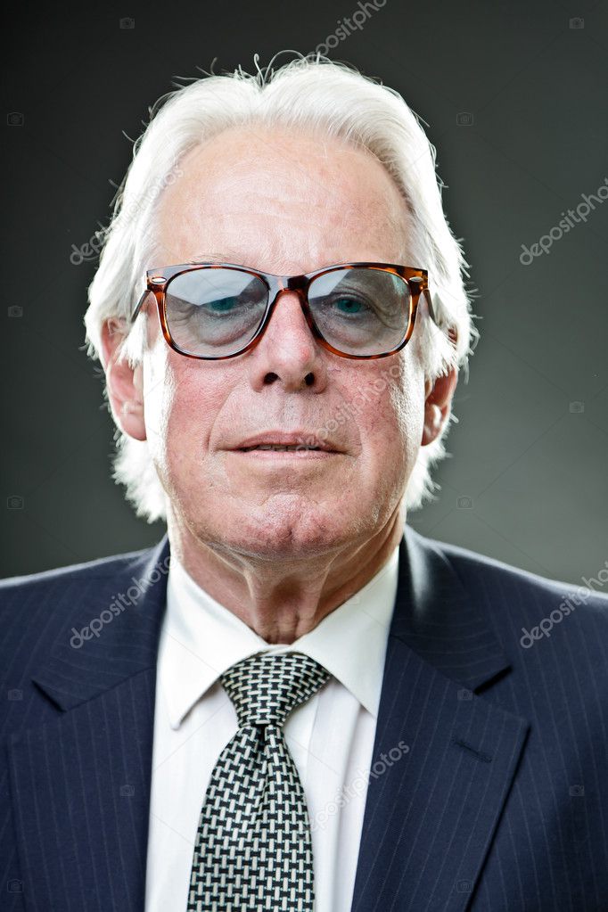 Senior stylish business man wearing vintage sunglasses with dark blue ...