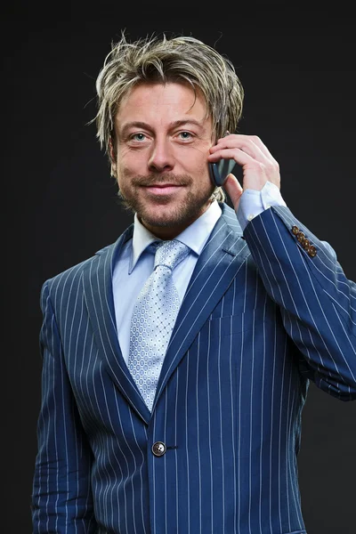 Snygga business man med kort blont hår, klädd i blå randig kostym och ljus blå slips. — Stockfoto