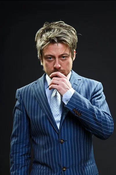 Stylischer Geschäftsmann mit kurzen blonden Haaren im blau gestreiften Anzug und hellblauer Krawatte. — Stockfoto