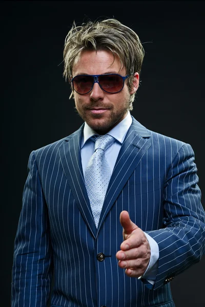 Stylový obchodní muž s krátkými blond vlasy, na sobě modrý proužkovaný oblek a světle modrou kravatu. — Stock fotografie