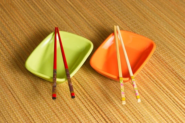 Two coloured sauce-boats with chopsticks — Stock Photo, Image