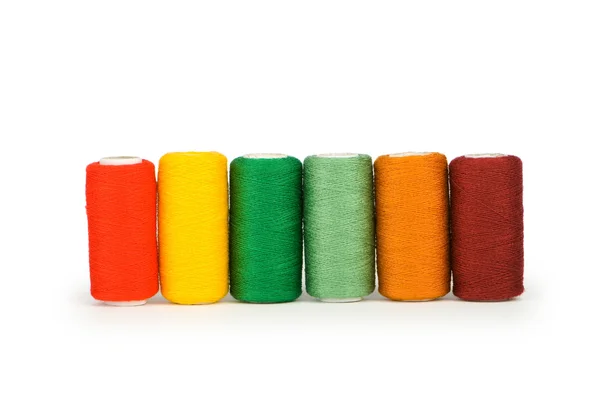 Ряд цветных нитей катушек — стоковое фото