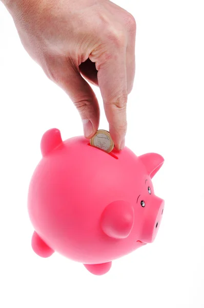 Hand invoegen munt aan piggy bank — Stockfoto