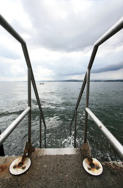 Escalera que conduce al mar en el lugar de baño Fotos de stock libres de derechos