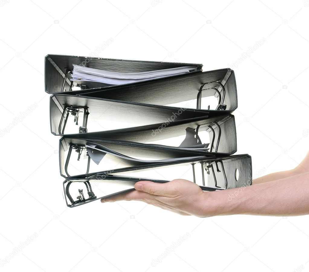Hands passing a pile of ring binders