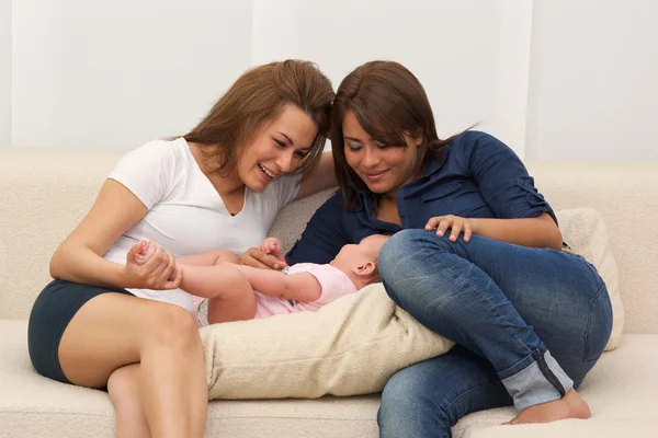 Zwei Schwestern spielen mit einem Baby — Stockfoto