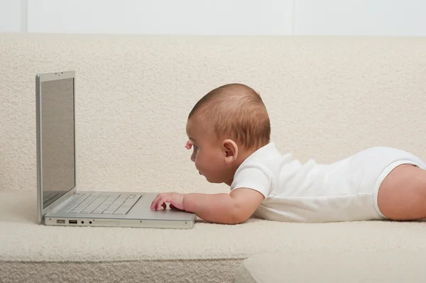 Baby med datamaskin – stockfoto