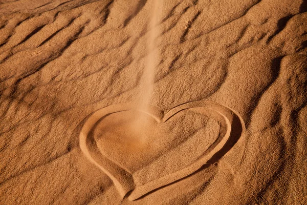 Сердце на песке, распыленное песками — стоковое фото