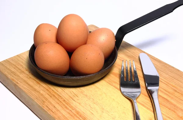 Seis huevos en una sartén negra con tenedor y cuchillo — Foto de Stock