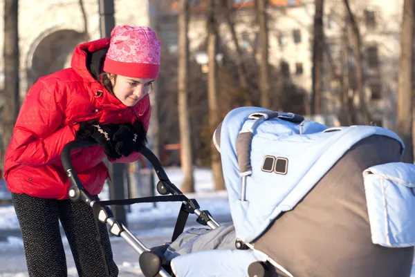 Young mother with a pram — Stock Photo, Image