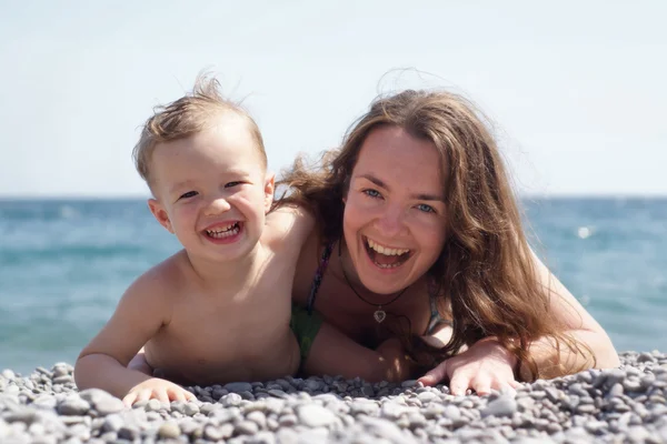 Moeder en baby aan de kust — Stockfoto
