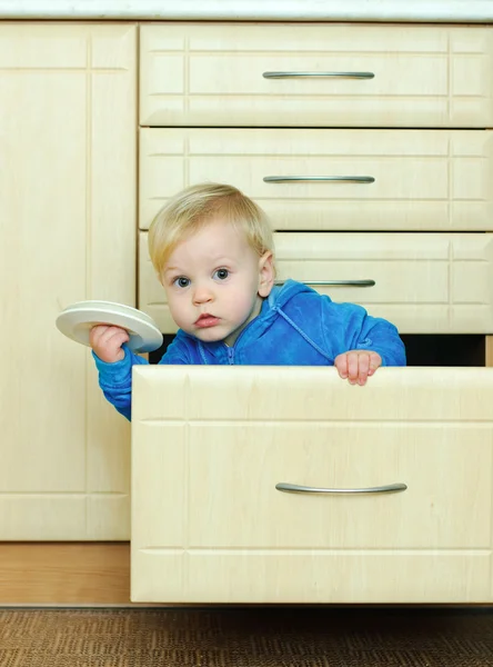 Мальчик в кухонном шкафу — стоковое фото