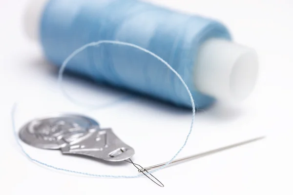stock image Needle threader, needle and spool of thread on white background