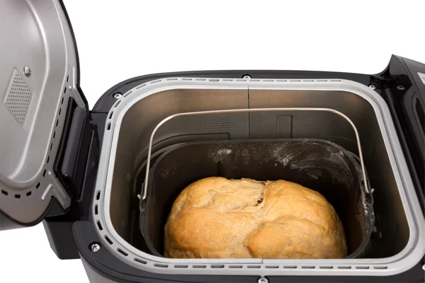 Pane fresco fatto in casa nella macchina del pane elettrica su un dorso bianco Foto Stock
