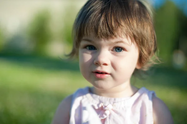 En liten flicka i en sommar park Stockbild