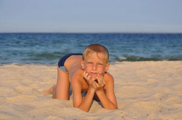 O rapaz com uma bola numa praia — Fotografia de Stock
