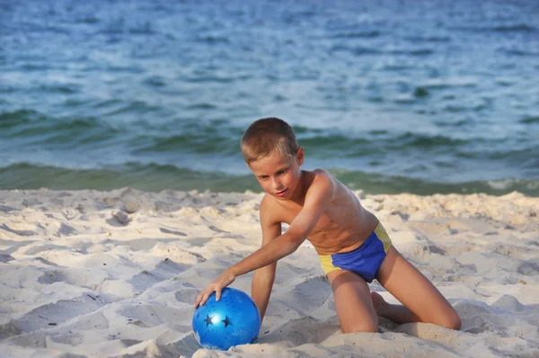 El chico con una pelota en una playa —  Fotos de Stock