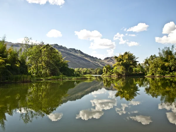 stock image Reflection of the clouds and mountains in the river