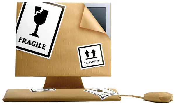 Computer, toetsenbord en muis verpakt in bruin papier geïsoleerd op een — Stockfoto