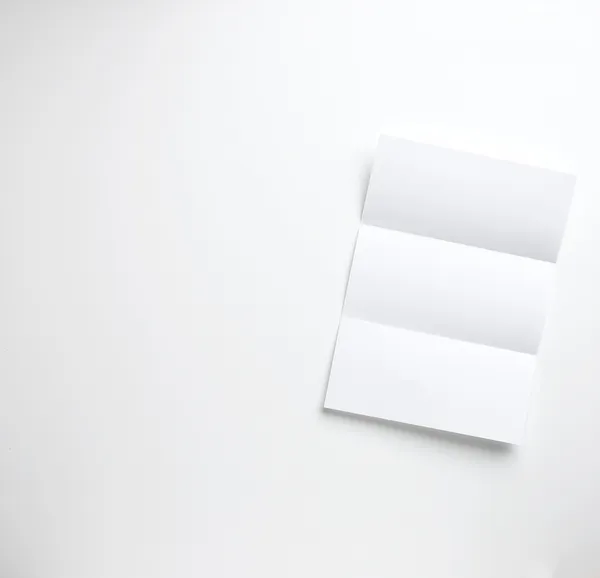空白の a4 のシート、白の背景に隠れて上の手紙紙 copyspace に畳んだ — ストック写真