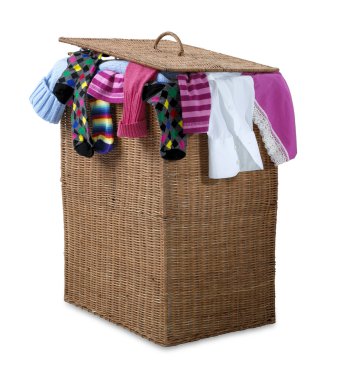 Overflowing wicker laundry basket isolated with clipping path clipart