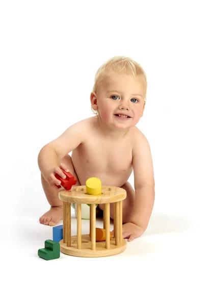 Bonito menino brincando com um classificador de forma isolado em um ba branco — Fotografia de Stock