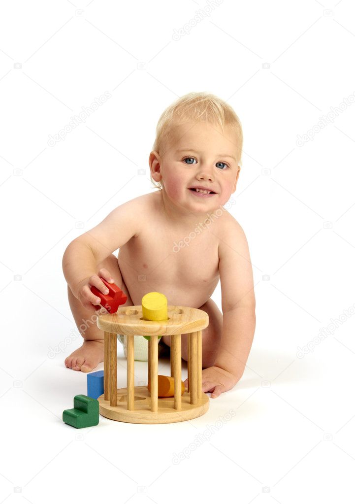 Cute baby boy playing with a shape sorter isolated on a white ba