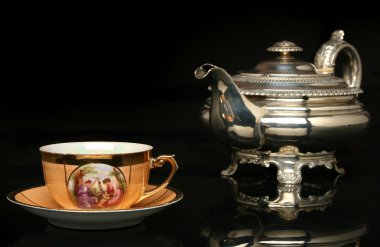 Gümüş çaydanlık ve antika bir Çin bardak çay